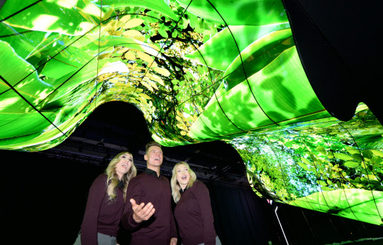 LG전자가 7일(현지시간)부터 미국 라스베이거스에서 열리는 CES 2020 전시회에 참가한다. LG전자는 부스 입구에 올레드 플렉서블 사이니지 200여 장을 이어 붙여 만든 '새로운 물결(New Wave)'이라는 이름의 조형물을 연출하고 관람객들의 이목을 집중시킨다. LG전자 모델들이 LG전자 전시관 입구에 마련된 올레드 조형물을 소개하고 있다. <LG전자 제공>